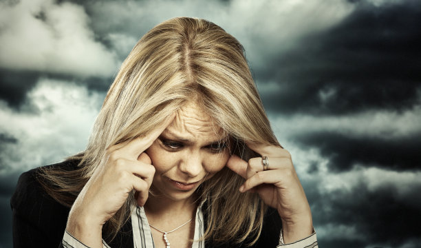 悲伤的金发职业女性双手抱头，因危机而沮丧图片下载