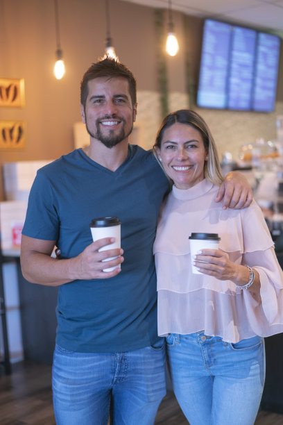 咖啡店里一对带着一次性杯子的幸福顾客夫妇的肖像图片下载