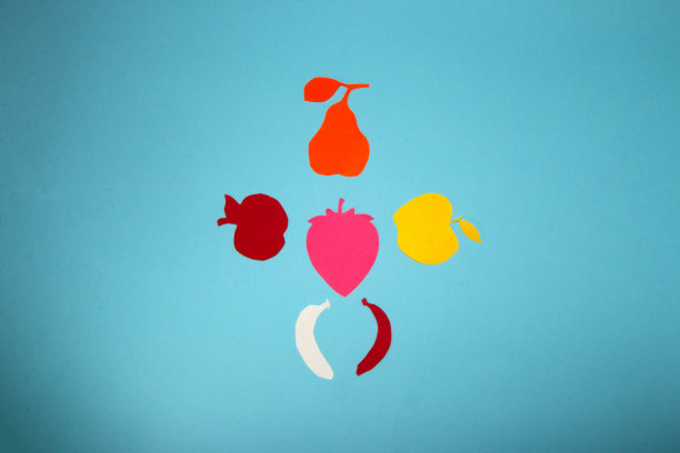 一个人的剪影纸水果，创意艺术设计在一个柔和的蓝色背景图片下载