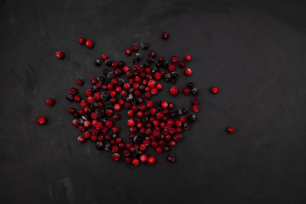 黑色背景上的冰冻蔓越莓。天然来源的维生素C，成分的健康冰沙或水果饮料图片下载