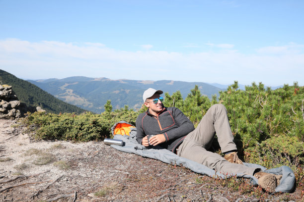 在山顶带热饮和睡袋的游客图片下载