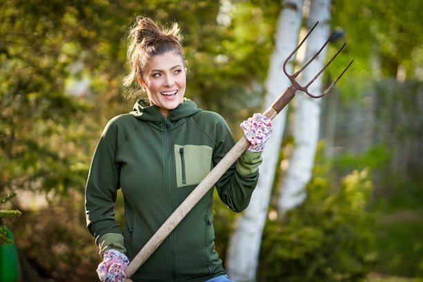 女人在花园里摆弄工具的照片图片下载
