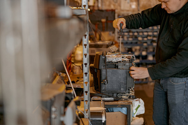 室内桌子上修理工用螺丝刀固定咖啡机的特写图片下载