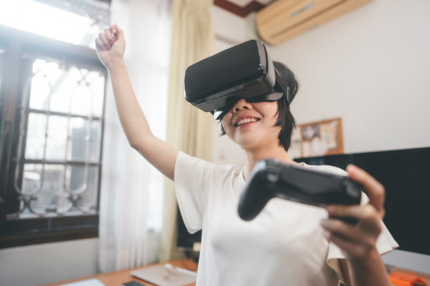 年轻的成年亚洲女性生活方式与虚拟现实技术玩视频游戏。图片下载