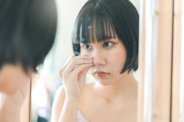 年轻的成年亚洲女性自己剪刘海的剪发在家里与自然的光。图片下载