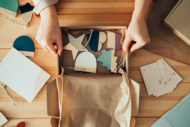 桌子上的看法，一个匿名的女人波特包装圣诞节装饰品的粘土航运在她的商店图片下载