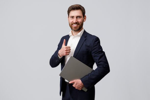 微笑的商人拿着面包，举着笔记本电脑，竖起大拇指图片下载