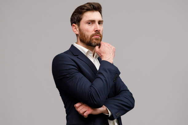 严肃的商人穿着经典的黑色西装，双手交叉看着镜头图片下载