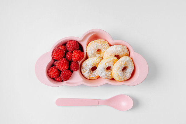 孩子们的早餐。盘子在云的形状，甜甜圈和浆果。孩子们的食物创意。图片下载