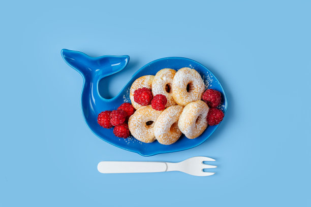 孩子们的早餐。鲸鱼形状的盘子，还有甜甜圈和浆果。孩子们的食物创意。图片下载
