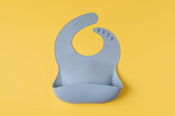 蓝色硅胶婴儿围兜。第一个婴儿用品晚餐。俯视图，平铺图片下载