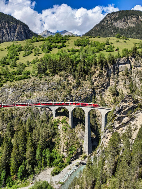 菲利苏尔附近的达沃斯山上的兰德瓦瑟高架桥。美丽的古老石桥上有一列移动的火车。春天的时间图片下载