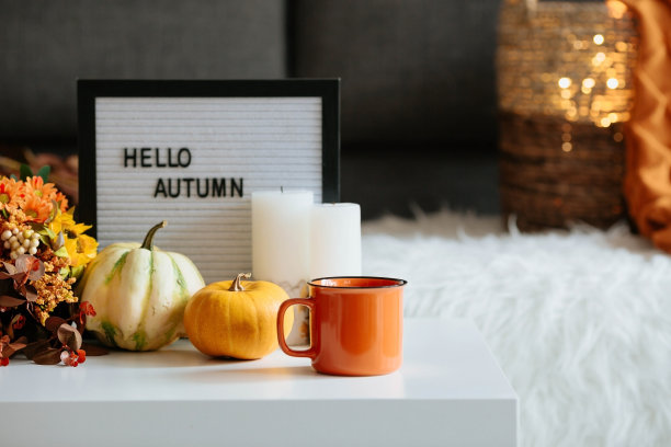 静物。客厅里的咖啡桌上放着一条毯子、南瓜和一杯茶。一个舒适的秋季概念。图片下载