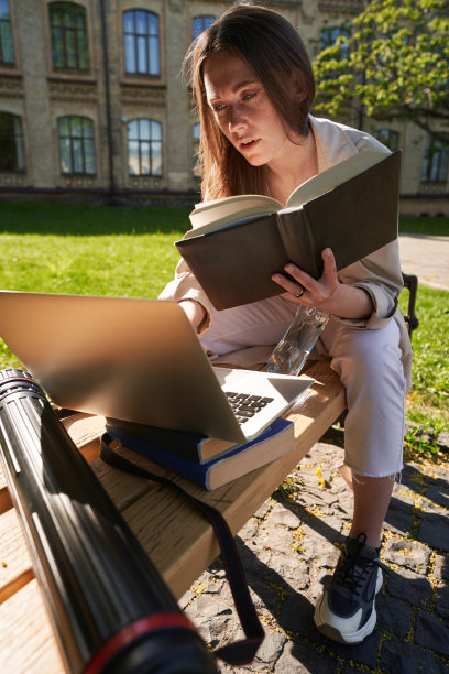 女生带着笔记本电脑在大学户外学习图片下载