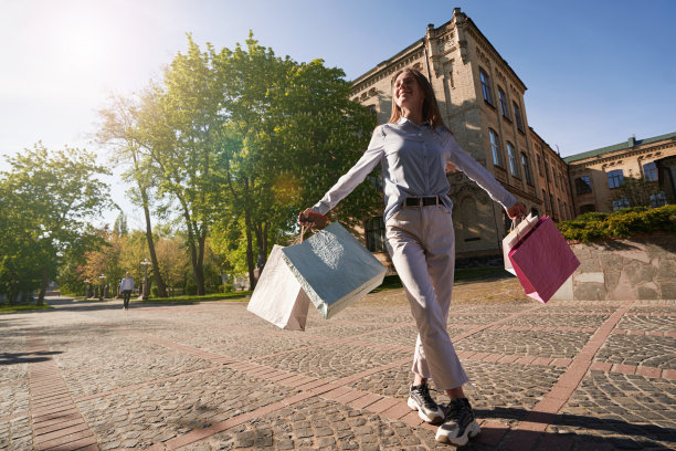 阳光明媚的日子里享受购物的快乐女性图片下载