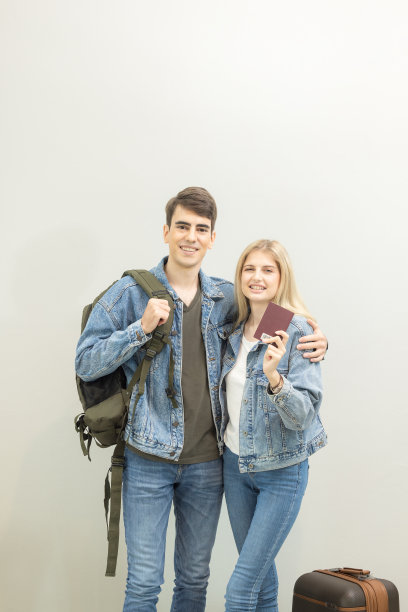 在机场，一对夫妇在休息室等待登机，人们在等待他们的航班。，一对快乐的年轻夫妇拿着他们的行李。图片下载