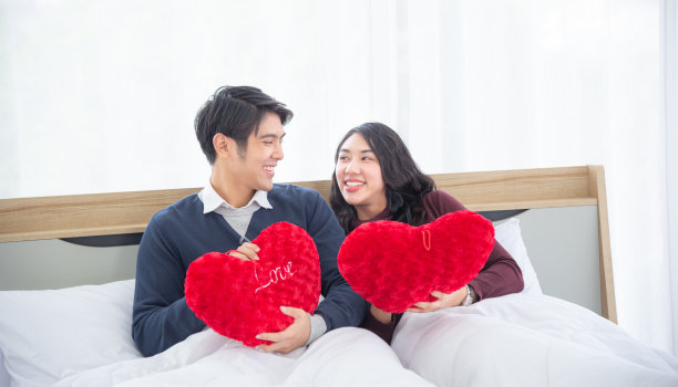 情人节。节日和幸福的概念。一对年轻的亚洲夫妇坐在床上。快乐。快乐有趣的爱人。亚洲夫妻在白色的床上放松微笑图片下载