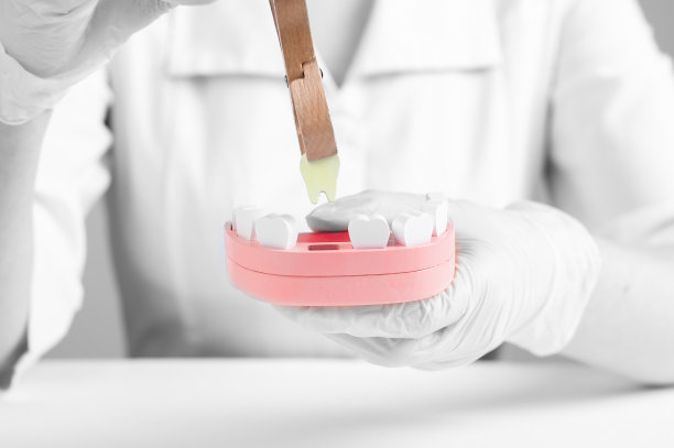 牙医用镊子从颌骨模型中拔出坏牙。生病，损坏的牙齿拔除。蛀牙、牙龈疾病、不良口腔护理习惯的后果。口腔，保健理念。图片下载