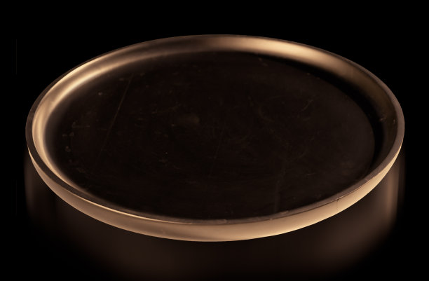 讲台黑色圆形托盘照亮黄色突出的圆圈和反映在黑色背景的产品介绍。图片下载