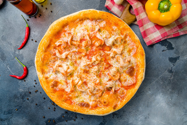 披萨与虾，奶酪和番茄酱俯视视图在板上的灰色桌面俯视视图图片下载