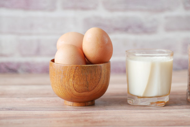 鸡蛋放在蝴蝶结里，桌上放一杯牛奶图片下载