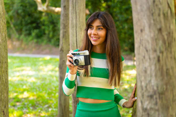 棕发白人女孩享受新鲜空气的自然假期与相机拍照，肖像微笑图片下载