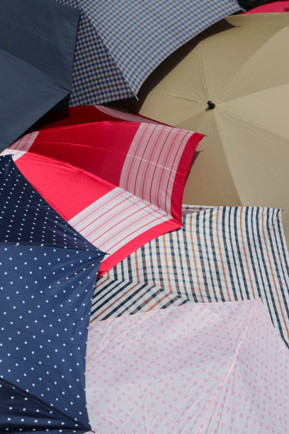 在阳光明媚的日子里，许多雨伞被打开晒干的场景。图片下载