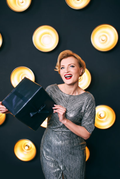 美丽成熟的女人与黑色礼物礼盒。聚会,庆祝活动的概念图片下载