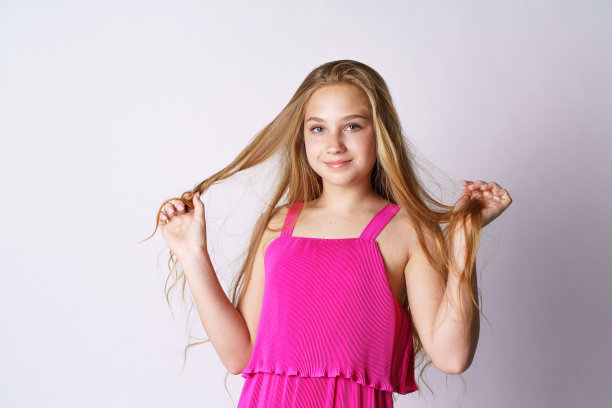 在白色背景下玩头发的可爱女孩图片下载