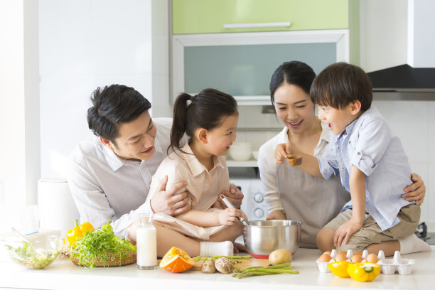 家庭厨房的血统。年轻的父母正在教两个学龄前的孩子做饭。- - -库存图片图片下载
