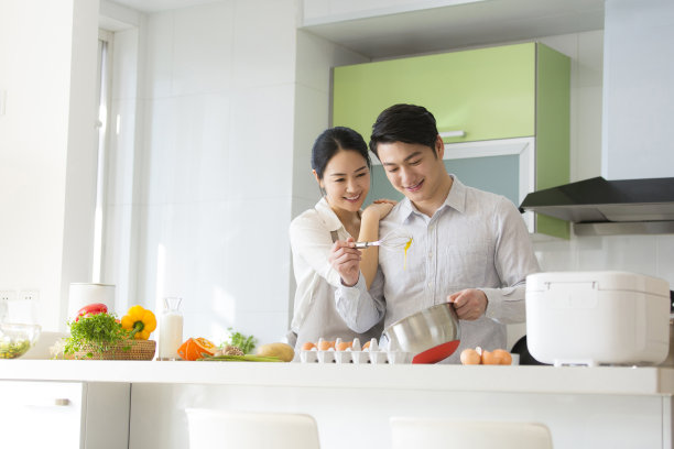 年轻夫妇在家庭厨房准备食物-库存照片图片下载