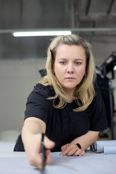 裁缝用专业剪刀裁剪布料的垂直照片图片下载