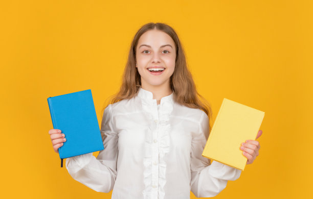 欢快的孩子在黄色的背景上展示学校作业，教育图片下载