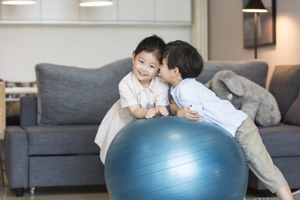 一个男孩和一个女孩在他们的家庭照片的客厅里亲密地玩耍图片下载