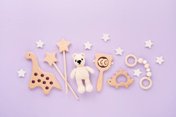 可爱的木制婴儿玩具在浅蓝色的背景。针织熊，恐龙玩具，珠子和星星。生态配件，豆袋和新生儿牙齿。平铺，俯视图图片下载