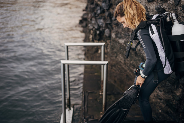 年轻的女潜水员在海里潜水和探索海底图片下载