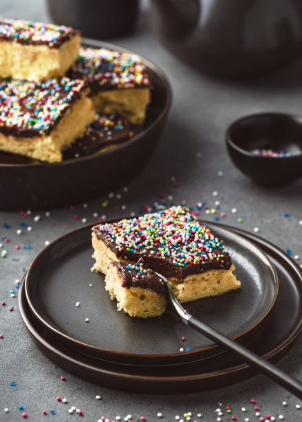 美味的自制蛋糕，黑巧克力糖霜和彩色糖撒在一个盘子里。图片下载