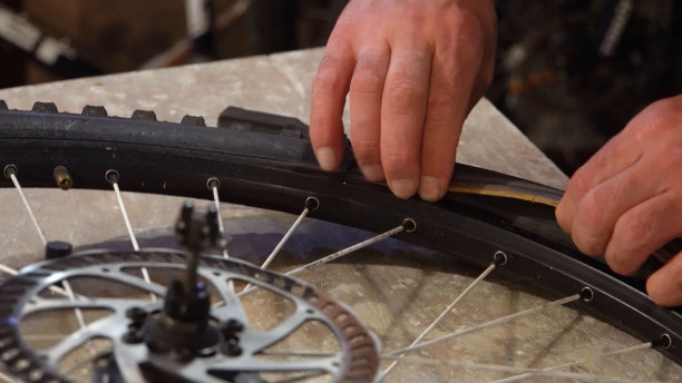 男人双手从轮子上拆下轮胎图片下载