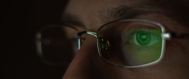 近景男子戴电脑眼镜，减少眼睛疲劳视力模糊看电脑屏幕图片下载