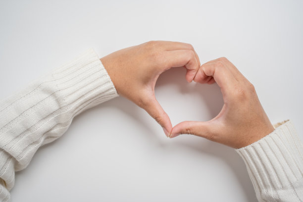 手在浅色背景上做心形图片下载
