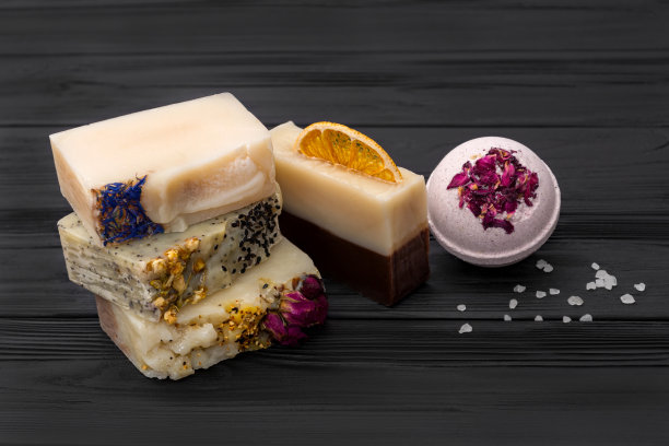 黑色木制背景上是美丽的天然手工肥皂、盐和炸弹图片下载