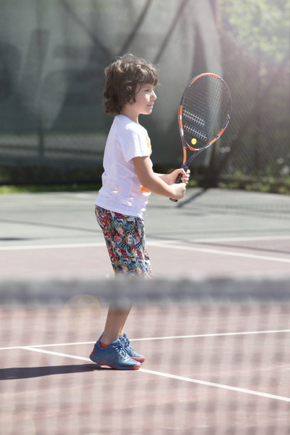 快乐的男孩和朋友在户外打网球图片下载