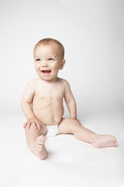 快乐的9个月大的婴儿坐在尿布上图片下载