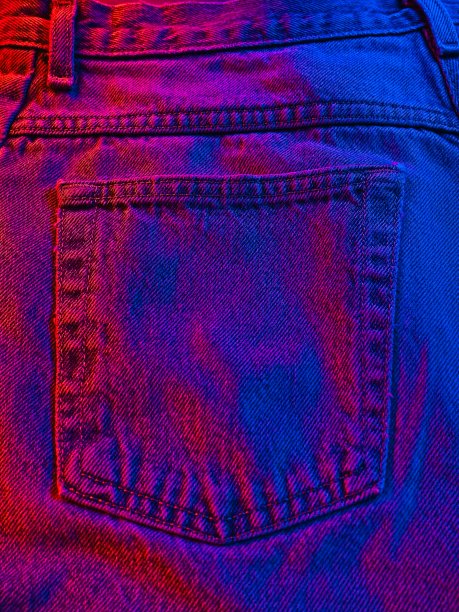一条蓝色牛仔裤的后口袋里涂着红色和蓝色的光，一种美国的时尚概念图片下载