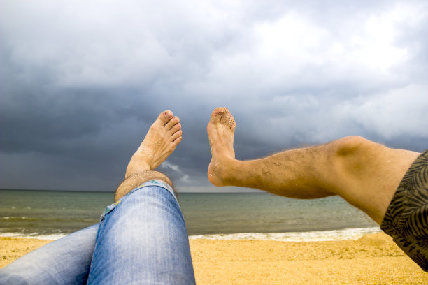 在海滩上模仿美女拍摄姿势的两个男人图片下载