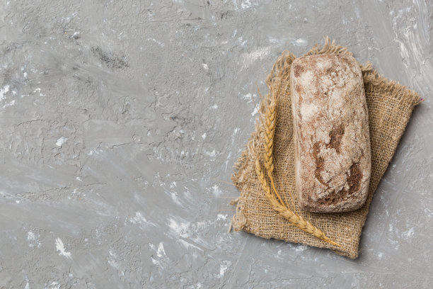 新鲜的黑麦面包在餐巾纸上质朴的背景，新鲜的面包俯视视图图片下载
