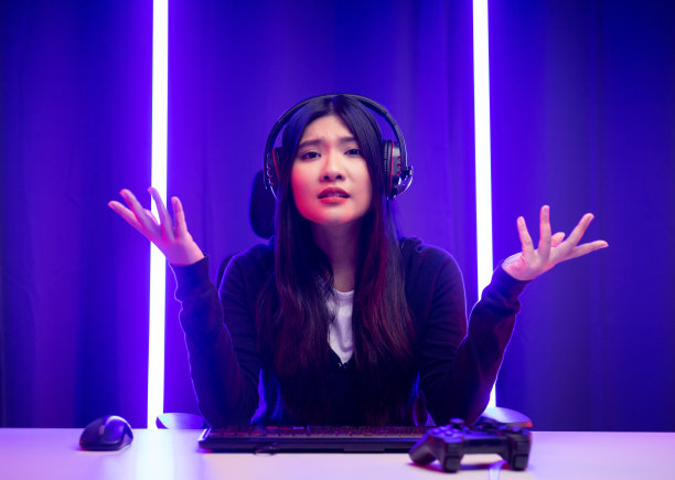 压力无聊年轻漂亮的亚洲女人玩游戏电脑电脑。中国女性玩家在家用键盘玩电子游戏感到悲伤。失去和错过了成为冠军的机会图片下载