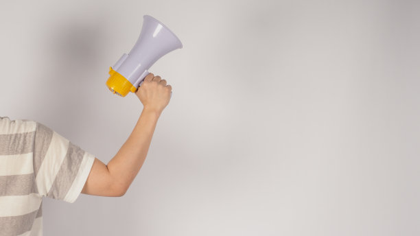 男性身体部分的转身和手是拿着扩音器在白色背景。图片下载