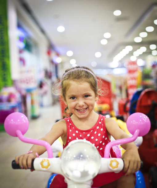 小女孩在一个玩具上欢呼图片下载