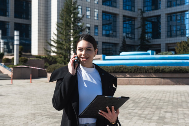 年轻自信的首席执行官商务女性去工作到办公大楼与她的员工开会。女领班在户外工作的时候也在忙。图片下载